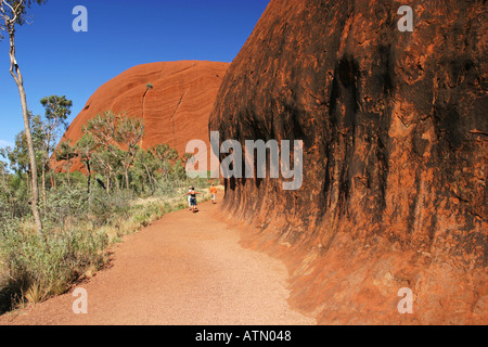 Touristen auf dem kreisförmigen Wanderweg rund um den berühmten Ayers Rock Uluru im Outback Wüste Australien Stockfoto