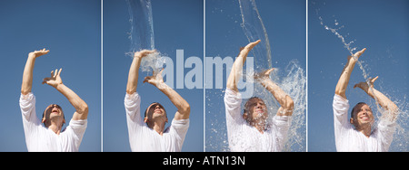 Mann immer mit Wasser vor einem blauen Himmel in Indien spritzte. Sequenz Stockfoto