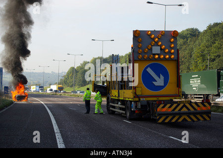 NOTFALL-DIENSTE SCHLIEßEN FAHRSPUREN IN SZENE DER BRENNENDE AUTO AUF M62 AUTOBAHN HARTE SCHULTER Stockfoto