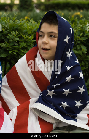 hispanischer Junge eingewickelt in eine amerikanische Flagge Stockfoto