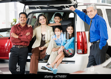 Spanische Familie mit Verkäufer im Autohaus Stockfoto