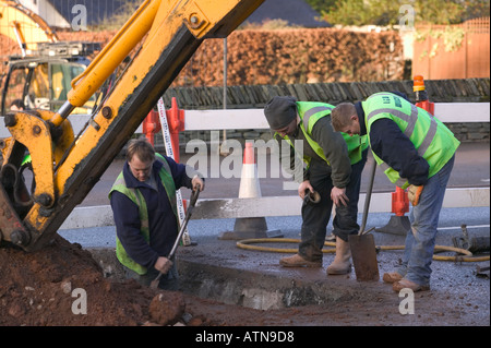 JCB gräbt ein Loch in der Straße an Baustellen Stockfoto