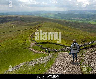 Wanderer, die absteigende Pfad von Pen-y-Gent, auf der Pennine Way, Yorkshire Dales National Park, North Yorkshire UK Stockfoto