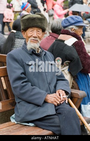 China, alte Distinguished Gentleman sitzen auf einer Bank, Lächeln, Porträt, Lijiang, Altstadt, Sifang Square, Yunnan Provinz Stockfoto