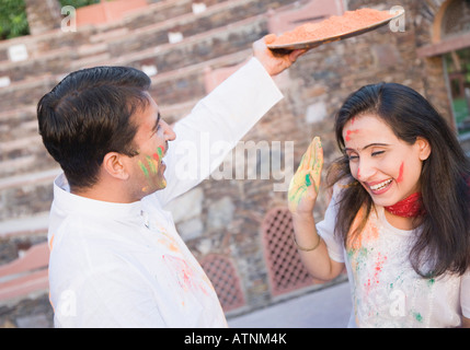 Mitte erwachsenes paar feiern holi Stockfoto