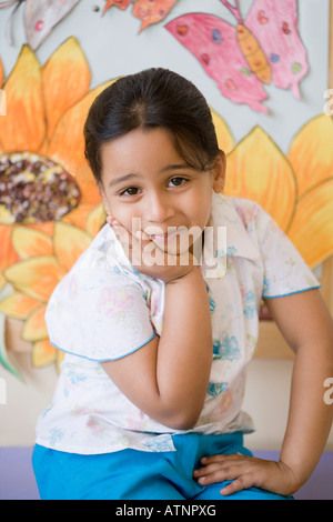 Porträt eines Mädchens mit der Hand am Kinn sitzen Stockfoto