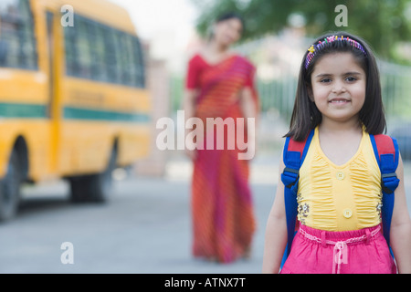 Porträt einer Schülerin lächelnd mit ihrem Lehrer im Hintergrund stehend Stockfoto