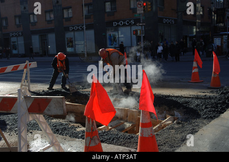 Bauarbeiter patch eine Ausgrabung Loch auf West 23rd Street im Stadtteil NYC Chelsea Stockfoto