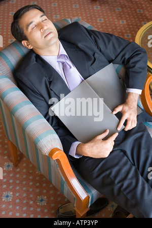 Erhöhte Ansicht eines Geschäftsmannes, schlafend in einem Sessel Stockfoto