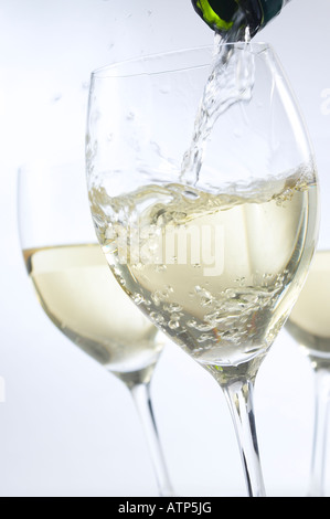 WEIßWEIN MIT FLASCHE GIEßEN Stockfoto