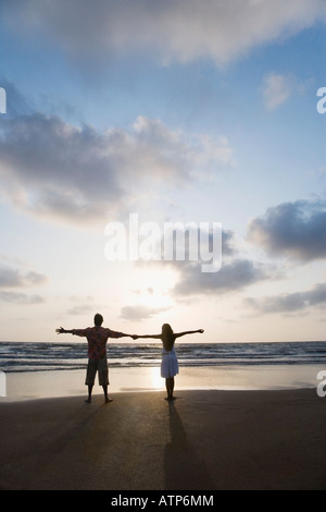 Rückansicht des ein paar stehen mit ihren ausgestreckten am Strand Stockfoto