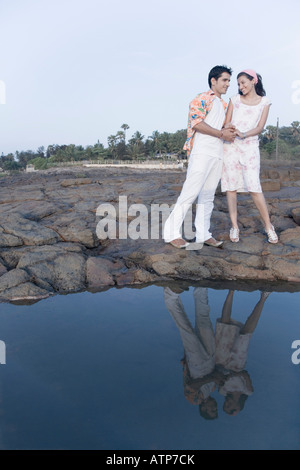 Junges Paar auf Felsen stehend mit ihren Händchen Stockfoto