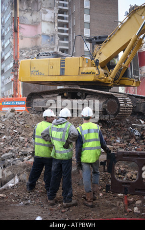 Bauarbeiter diskutieren Arbeit auf den Abriss einer Wohnsiedlung. Stockfoto
