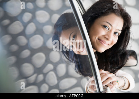 Porträt einer jungen Frau, die durch ein Autofenster zu spähen Stockfoto