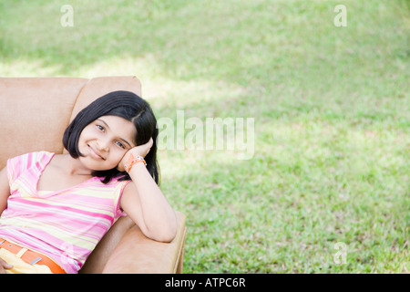 Porträt eines Mädchens in einem Sessel sitzend und lächelnd Stockfoto