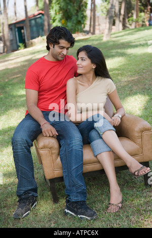 Junges Paar in einem Sessel sitzend Stockfoto