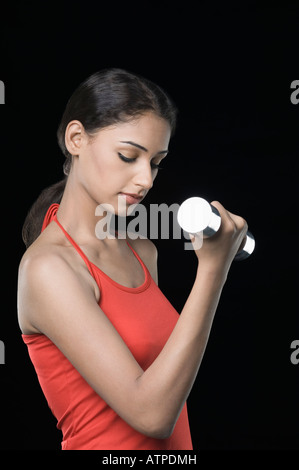 Seitenansicht einer jungen Frau mit einer Hantel trainieren Stockfoto