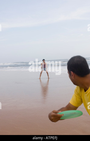 Zwei junge Männer spielen mit einem Kunststoff-Scheibe am Strand Stockfoto