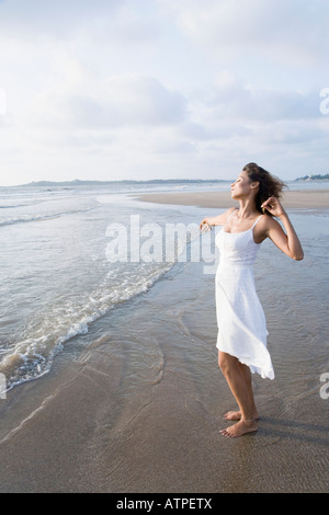 Seitenansicht einer jungen Frau, die Strecken am Strand Stockfoto