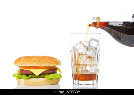 Cheeseburger mit Salat und Tomate und gießen Natron in ein Glas mit Eiswürfeln reflektiert auf weißem Hintergrund Stockfoto