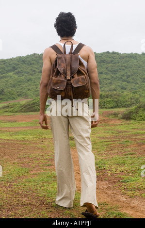 Rückansicht eines jungen Mannes mit einem Rucksack auf dem Rücken Stockfoto