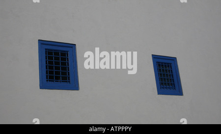 Außenansicht eines traditionellen Gebäudes mit kleinen blauen Fenstern und weiß getünchten Wänden in Sidi Bou Said, einer Küstenstadt in der Nähe von Tunis, Tunesien. Stockfoto