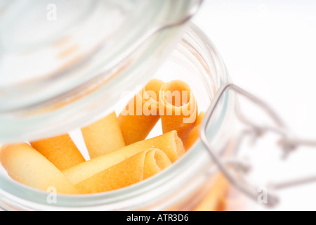 Glasglas voller Keks locken vor weißem Hintergrund Stockfoto