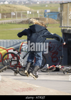 Kind auf Rollerblades über eine Rampe in einen skatepark Stockfoto