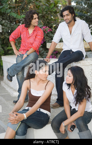 Zwei junge Männer und zwei junge Frauen sitzen zusammen Stockfoto