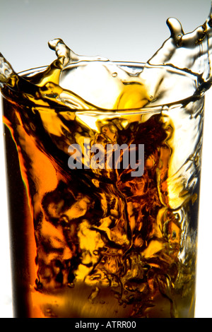 Lauffeuer der Eiswürfel Spritzwasser in Glas Whiskey auf weißem Hintergrund Stockfoto