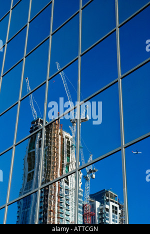 Bau der Pan Halbinsel Türme spiegelt sich in einem Glas verkleideten Gebäude in Docklands London England UK Stockfoto