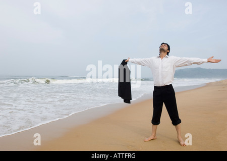 Geschäftsmann, stehen am Strand mit ausgestreckten Armen Stockfoto