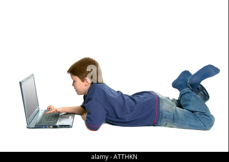 Junge zur Festlegung mit einem Laptop auf einen weißen Hintergrund mit leichten Schatten isoliert Stockfoto