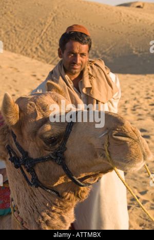 Porträt eines schönen männlichen Kamel Treibers mit seinem Kamel in der Wüste Thar grenzt an Indien und Pakistan Stockfoto