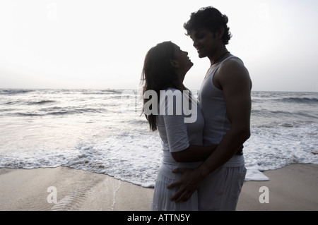 Silhouette eines jungen Paares umarmen einander am Strand, Goa, Indien Stockfoto