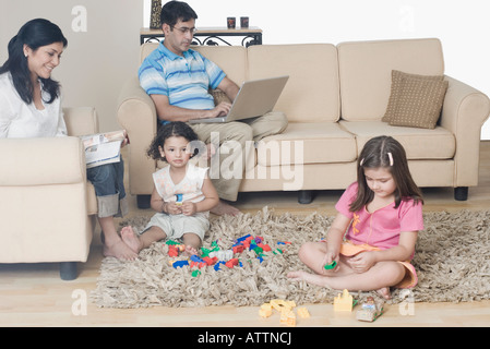 Mitte erwachsenes paar mit ihren beiden Töchtern in einem Wohnzimmer Stockfoto