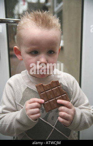 Ein Kleinkind Essen eine große Tafel Milchschokolade Stockfoto