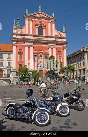 Ljubljana, Slowenien. Franziskaner Kirche der Mariä Verkündigung in Presernov Trg mit Harley Davidson Motorräder geparkt vor Stockfoto