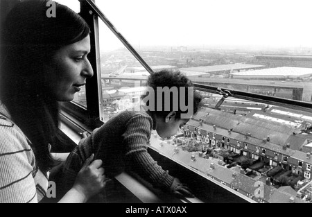 Junge alleinerziehende Mutter mit ihrem Kleinkind in Birmingham Hochhaus mit Blick auf Autobahnkreuz Leben. Stockfoto