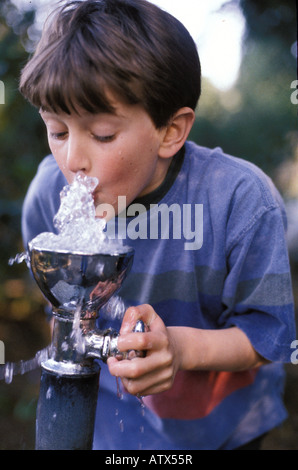 Junge Trinkwasser aus Brunnen im Park. Stockfoto