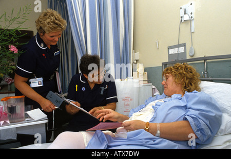 Bezirk Krankenschwestern Beratung mit einer Frau über Arrangements auf vorzeitige Entlassung Krankenhaus für Betreuung zu Hause. Stockfoto