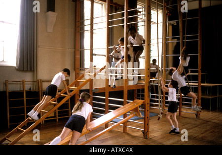 Mädchen und jungen in der Schule, Klettern Apparat in Süd-London-Grundschule Stockfoto