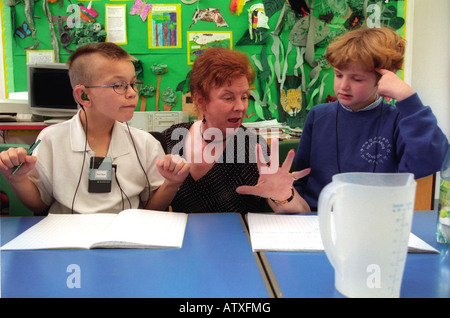 Weibliche Lehrer arbeiten mit gehörlosen Kindern in einer Sonderschule. Stockfoto