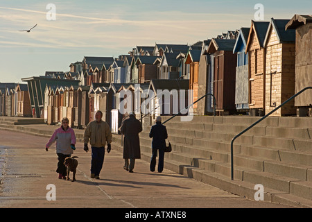 Walton am Naze Strandhütten und Wanderer im winter Stockfoto