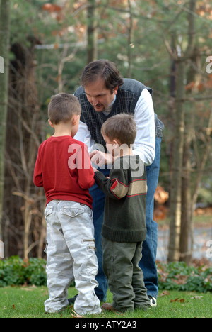 Männliche Mitglieder einer Großfamilie spielen Fußball in ihrem Vorgarten am Thanksgiving day Stockfoto