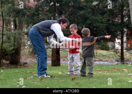 Männliche Mitglieder einer Großfamilie spielen Fußball in ihrem Vorgarten am Thanksgiving day Stockfoto