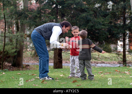 Männliche Mitglieder einer Großfamilie spielen Fußball in ihrem Vorgarten am Thanksgiving day Stockfoto