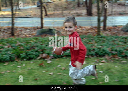 Männliche Mitglieder einer Großfamilie spielen Fußball in ihrem Vorgarten am Thanksgiving day Stockfoto