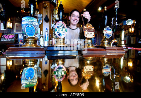 Eine Bardame zieht ein altmodischer Pint in einem viktorianischen Pub mit einer Kupferstange und real Ale aus Handpumpen Stockfoto