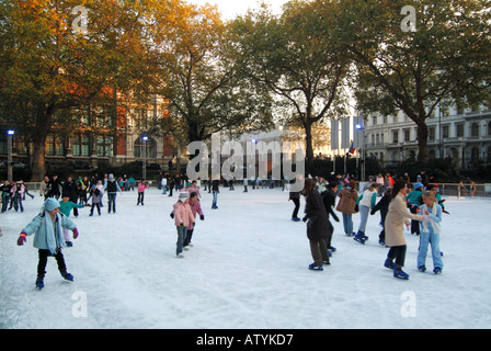 Erwachsene Kinder & Kinder auf Schlittschuhen zu Weihnachten Winter Eislaufplatz am Natural History Museum in South Kensington West London England Großbritannien Stockfoto